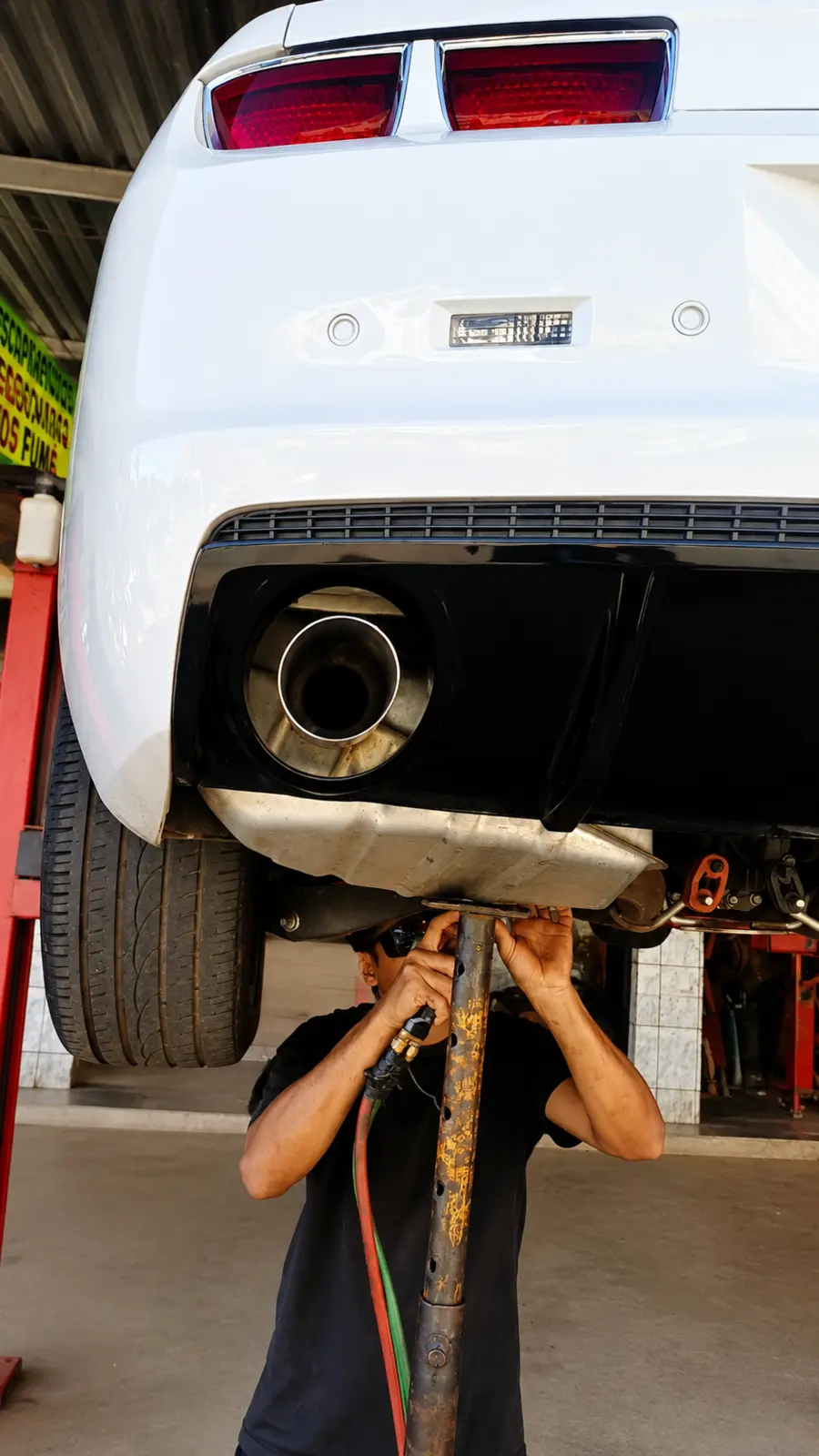 Profissional trabalhando no escapamento de um veículo